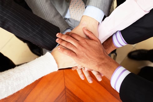 Image of business people hands on top of each other. View from above