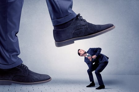 Young handsome businessman getting crushed by a big formal shoe-1